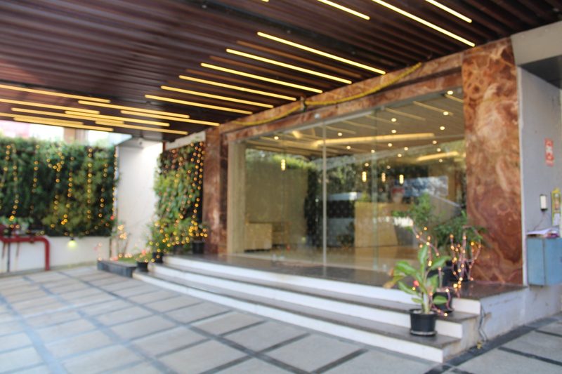 Hotel glass entrance with wide steps and plants