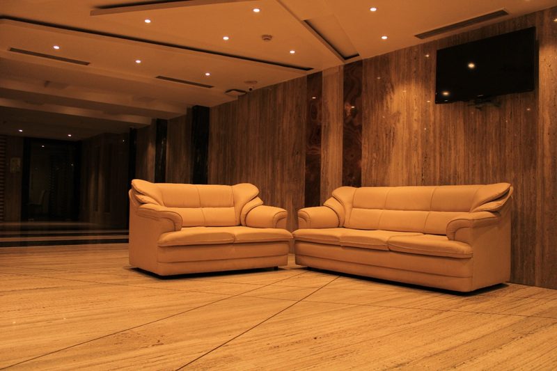 Lounge area with two tan sofas and a wood-panelled wall